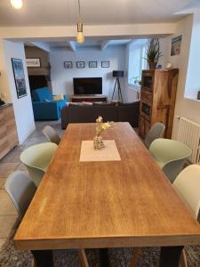 a living room with a wooden table and chairs at Maison cosy 115m² près de la mer in Hauteville-sur-Mer