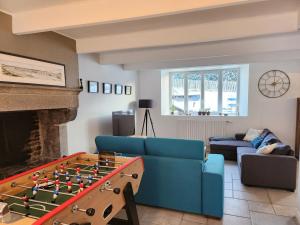 ein Wohnzimmer mit einem blauen Sofa und einem Kamin in der Unterkunft Maison cosy 115m² près de la mer in Hauteville-sur-Mer