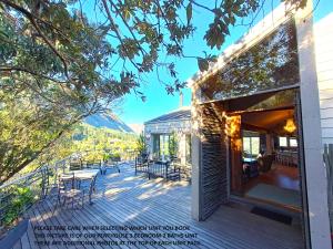 a house with a deck with tables and chairs at Mount Rhodes Guesthouse, three separate units, please select either three bedroom, two and a half bedroom or one bedroom in Cape Town