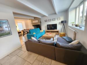 a living room with a couch and chairs and a table at Maison cosy 115m² près de la mer in Hauteville-sur-Mer