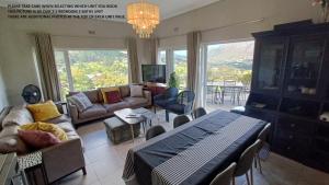 a living room with a couch and a table at Mount Rhodes Guesthouse, three separate units, please select either three bedroom, two and a half bedroom or one bedroom in Cape Town