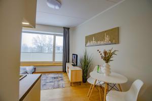 uma sala de estar com uma mesa branca e uma janela em Fortune Apartments - City, Contactless em Tartu