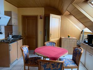 a kitchen with a pink table and chairs at Gästehaus Monika in Hornbach