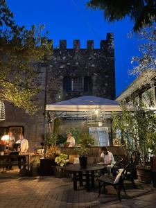 a group of people sitting at tables in a patio at Quel Castello di Diegaro in Cesena
