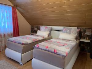 dos camas sentadas una al lado de la otra en una habitación en Gästehaus Monika, en Hornbach