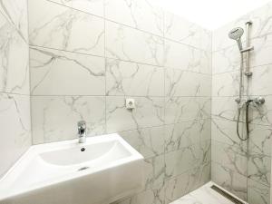 a white bathroom with a sink and a shower at FeelHome-Margareten-2 Gäste-WiFi-SmartTV in Vienna