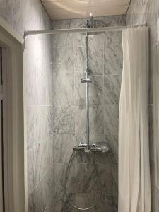 La salle de bains est pourvue d'une douche avec rideau de douche. dans l'établissement Yksiö Punavuoresta, à Helsinki