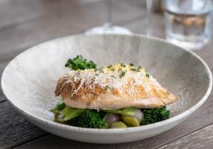 una ciotola di cibo con pesce e broccoli su un tavolo di Rocksalt Rooms a Folkestone