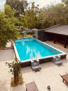 a large swimming pool with stairs in a backyard at Royal Nest in Polonnaruwa
