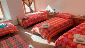 a bedroom with three beds and a rug at Chasa Crusch in Sent