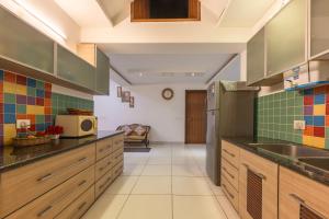 cocina grande con armarios de madera y fregadero en 3BDR Cottage Kasauli by Humble stay, en Kasauli