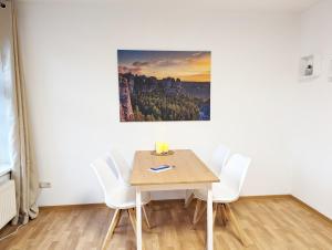 a table and chairs in a room with a painting on the wall at HW1 - Urlaubsmagie - Sauna&Whirlpool zum Entspannen in Sebnitz +65 photos