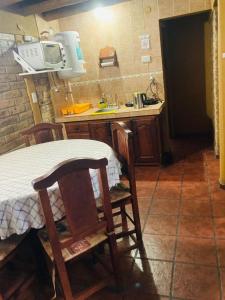 a small kitchen with a table and a microwave at Hermosa cabaña con vista a la montaña in Tunuyán