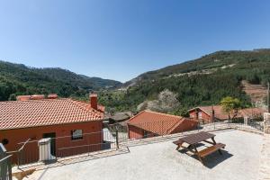 a bench sitting on top of a building with a mountain at Maria da Vinha - Country House in Góis