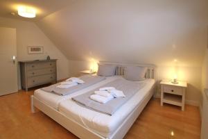 a bedroom with a white bed with towels on it at Linge 4_ Whg_ 1_ Hygge in Wrixum