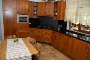 a kitchen with wooden cabinets and a wooden table with a tableablish at Cabana din poiană in Câmpulung Moldovenesc