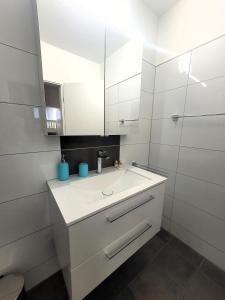 uma casa de banho branca com um lavatório e um espelho em Winterberg Appartement 21116 em Winterberg