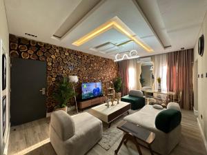 a living room with a couch and a tv at MAJESTIC VILLA RESIDENCE in Ankuru