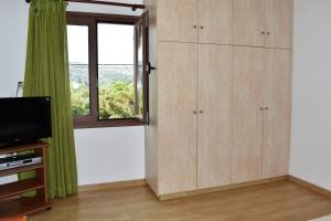 een woonkamer met een tv en een raam bij Madaro Traditional House in Arménoi