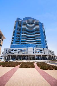 ein hohes blaues Gebäude mit einem Weg davor in der Unterkunft Home Away From Home - New Studio in Dubai