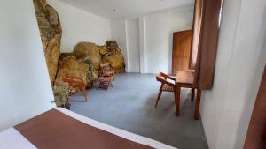 a room with chairs and a table and some rocks at Rock n Fall Nature Resort in Ella