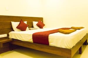 een slaapkamer met een groot bed met een houten hoofdeinde bij KRR Grand inn in Coimbatore