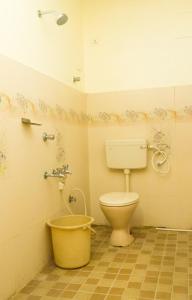 een badkamer met een toilet en een emmer bij KRR Grand inn in Coimbatore