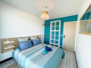 una camera da letto con letto e cuscini blu di Calypso face à la mer - Plages et port a Marsiglia