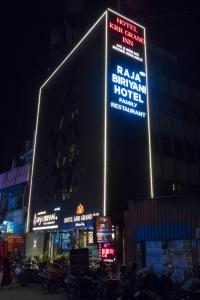een gebouw met borden aan de zijkant 's nachts bij KRR Grand inn in Coimbatore