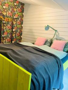 a bed with colorful pillows on it in a room at Beautiful house on an island near Amsterdam 