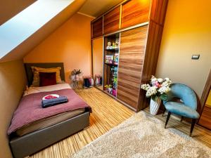 um quarto com uma cama e uma cadeira azul em Spa Residence Családi Wellness Apartman em Veszprémfajsz
