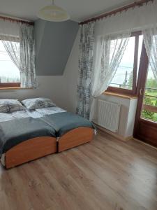 a bedroom with a bed and two windows at Pokoje u Matusa in Gliczarów