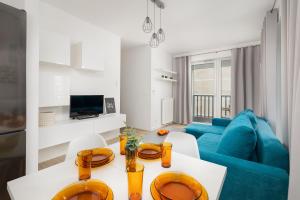 uma sala de estar com um sofá azul e uma mesa em Bulwar Piastowski Chic Apartment em Szczecin