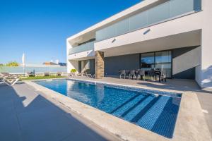 a swimming pool in front of a house at Villa Aboim - BY BEDZY in Guia