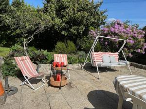 two chairs and a hammock on a patio at Casa dos três rapazes in Monte Córdova