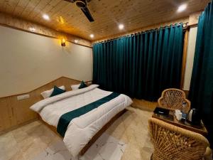 a bedroom with a bed and a window with blue curtains at Hotel Mid Orchard Kasol l River Side in Kasol