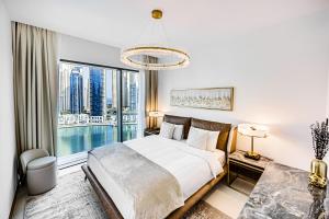 a bedroom with a bed and a large window at Elegant family apartment in Marina Vida Residence in Dubai