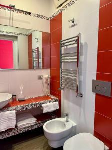 a red and white bathroom with a toilet and a sink at Pope's bridge in Rome