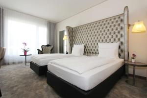 a hotel room with two beds and a headboard at ARCOTEL John F Berlin in Berlin