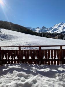 ein schneebedeckter Zaun mit einem schneebedeckten Hang in der Unterkunft l'appart accès direct sur les pistes in Le Dévoluy