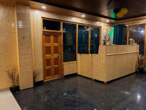 a lobby with a wooden door and a bar at Hotel Mid Orchard Kasol l River Side in Kasol
