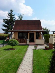 una pequeña casa con techo marrón y patio verde en Ferienhaus Mecklenburgische Seenplatte, 