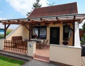 una pérgola en una casa con una mesa en Ferienhaus Mecklenburgische Seenplatte, 