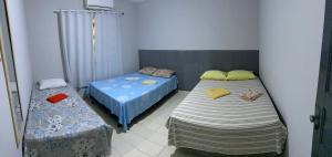 2 camas individuales en una habitación con 3 camas individuales que establece que en Casa para temporada Cânions en Canindé de São Francisco