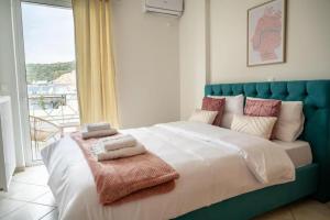 1 dormitorio con 1 cama grande y toallas. en Breathtaking view apartment in Glyfada (AS_D1), en Atenas