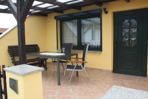 un patio con una mesa y sillas y una puerta negra en Ferienhaus Mecklenburgische Seenplatte, 