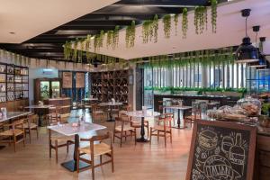 een restaurant met tafels, stoelen en ramen bij JA Ocean View Hotel in Dubai