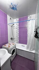 uma casa de banho roxa com um WC e um chuveiro em Quiet appartment in Bishkek city em Bishkek