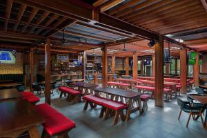 un ristorante con tavoli in legno e panche rosse di JA Ocean View Hotel a Dubai