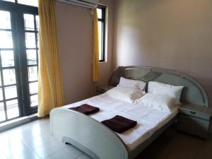 a bedroom with a bed with white sheets and pillows at Mirihana Residence in Nugegoda